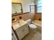 Bathroom features a tile surround, toilet, vanity with storage, and a window for natural light at 6411 26Th W St, Bradenton, FL 34207