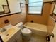 Bathroom with tile walls featuring a toilet, vanity, and tub with a window for natural light at 6411 26Th W St, Bradenton, FL 34207
