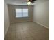 Cozy bedroom featuring a ceiling fan, tile floors, and natural light from a window at 6411 26Th W St, Bradenton, FL 34207