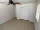 Bedroom with neutral walls, ceiling fan, tile floor, and large closet doors at 6411 26Th W St, Bradenton, FL 34207