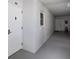 Neutral hallway with a gray floor, white walls and window, with a view of the entrance door at 7 Elgin Pl # 510, Dunedin, FL 34698