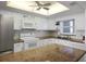 Well-lit kitchen featuring white cabinets, granite countertops, and modern appliances for easy meal preparation at 7 Elgin Pl # 510, Dunedin, FL 34698