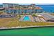 Aerial view of a pool with lounge chairs at waterfront condo community on a bright sunny day at 7 Elgin Pl # 510, Dunedin, FL 34698