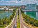 Aerial view of roadway featuring manicured landscaping, tropical foliage, and a tranquil waterfront at 736 Island Way # 1101, Clearwater Beach, FL 33767