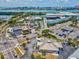 Aerial view of an intersection with commercial buildings, a gas station, and some parking with palm tree landscaping at 736 Island Way # 1101, Clearwater Beach, FL 33767