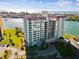 Exterior of a high-rise building with bay views from multiple balconies, manicured lawn and driveway at 736 Island Way # 1101, Clearwater Beach, FL 33767