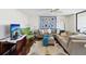 Cozy living room with a large sectional couch, a cowhide rug, and a vibrant quilt on the wall at 736 Island Way # 1101, Clearwater Beach, FL 33767