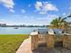 Outdoor kitchen featuring built-in grill, stone surround, and a gorgeous waterfront view at 736 Island Way # 1101, Clearwater Beach, FL 33767