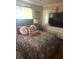 Comfortable bedroom featuring a patterned bedspread, bedside table, and a dresser at 7435 46Th N Ave, St Petersburg, FL 33709