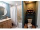 Well-lit bathroom featuring a shower-tub combo, wooden vanity, commode, and modern lighting at 750 4Th S Ave # 403C, St Petersburg, FL 33701