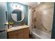 This bathroom has wood cabinets, a tub, and is painted blue at 750 4Th S Ave # 403C, St Petersburg, FL 33701