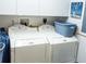 Bright laundry room area with two new front-load washing machine and dryers and built-in storage cabinets at 750 4Th S Ave # 403C, St Petersburg, FL 33701
