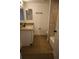 Bathroom featuring granite countertops, a white vanity, and laminate flooring at 7932 Palatine Dr, Hudson, FL 34667