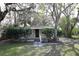 Charming single-story home featuring a quaint front porch and lush, mature trees in a serene setting at 7932 Palatine Dr, Hudson, FL 34667