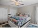 Bedroom with floral bedding, fan, and closet doors providing storage space at 811 College Leaf Way, Ruskin, FL 33570