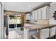 Bright kitchen with white cabinets, a breakfast bar, and sliding glass doors leading to the outdoor area at 811 College Leaf Way, Ruskin, FL 33570