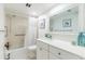 Well-lit bathroom featuring an updated vanity and tiled shower and tub with handrails at 825 S Gulfview Blvd # 202, Clearwater Beach, FL 33767