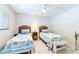 Clean, bright bedroom featuring twin beds, coastal decor, ceiling fan, and light wood flooring at 825 S Gulfview Blvd # 202, Clearwater Beach, FL 33767
