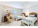 Bright bedroom featuring two twin beds, coastal decor, ceiling fan, and light wood flooring at 825 S Gulfview Blvd # 202, Clearwater Beach, FL 33767