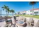 Community brick fire pit surrounded by chairs, palm trees, and beachfront condominium buildings at 825 S Gulfview Blvd # 202, Clearwater Beach, FL 33767