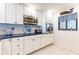 Modern kitchen with white cabinets, stainless steel appliances, and blue countertops at 825 S Gulfview Blvd # 202, Clearwater Beach, FL 33767