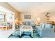 Comfortable living room with light blue furniture, beach-themed decor, and access to the outside deck at 825 S Gulfview Blvd # 202, Clearwater Beach, FL 33767