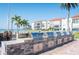 Outdoor grilling area with multiple stainless steel grills, brick surround, and seating near waterfront at 825 S Gulfview Blvd # 202, Clearwater Beach, FL 33767
