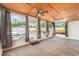 Enclosed sunroom featuring large windows, ceiling fans, and an exit to a patio at 8302 W Pocahontas Ave, Tampa, FL 33615