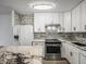 Stylish kitchen with white cabinets, granite countertops, stainless steel appliances, and chic mosaic backsplash at 9481 Highland Oak Dr Dr # 508, Tampa, FL 33647