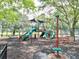 Community playground area with slides and swings, surrounded by woodchips and a grassy park at 9481 Highland Oak Dr Dr # 508, Tampa, FL 33647