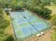 Aerial view of the community tennis courts with benches, lighting, and greenery all around at 9481 Highland Oak Dr Dr # 508, Tampa, FL 33647