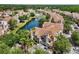 Aerial view of residences with a pond featuring a fountain and mature landscaping at 10434 Villa View Cir, Tampa, FL 33647