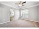 Bedroom featuring plush carpet, crown molding, ceiling fan, a window, and an open door at 10434 Villa View Cir, Tampa, FL 33647