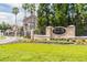 Charming community entrance with The Villas Condominiums sign, enhanced by colorful flower beds and manicured lawn at 10434 Villa View Cir, Tampa, FL 33647