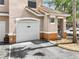 Side exterior showing the garage with white door and trimmed landscaping at 10434 Villa View Cir, Tampa, FL 33647