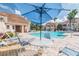 Relaxing pool area with comfortable lounge chairs and a shaded table, perfect for enjoying sunny days at 10434 Villa View Cir, Tampa, FL 33647