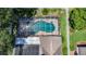 An aerial view of a screened-in pool and spa with solar panels offers a private backyard oasis at 11216 Longbrooke Dr, Riverview, FL 33579