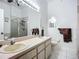 Bathroom with double sinks, large mirror, tiled floors, and a glass-enclosed shower at 11216 Longbrooke Dr, Riverview, FL 33579