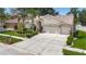 Beautiful single-story home with a well-manicured lawn, arched entry, and three-car garage at 11216 Longbrooke Dr, Riverview, FL 33579