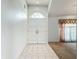 Bright foyer with double doors and tiled flooring seamlessly transitioning into carpeted living space at 11216 Longbrooke Dr, Riverview, FL 33579