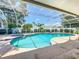Screened-in pool with a spa, surrounded by a white fence and green landscaping offers a private backyard oasis at 11216 Longbrooke Dr, Riverview, FL 33579