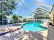 A screened-in pool features a spa and lush landscaping, perfect for relaxation and outdoor enjoyment at 11216 Longbrooke Dr, Riverview, FL 33579