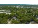 An aerial view of a neighborhood with lush greenery and a single Gathering home featuring solar panels and a private pool at 1155 Withlacoochee St, Safety Harbor, FL 34695