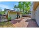 A quaint backyard featuring a brick-paved patio, a detached garage, and lush greenery at 1155 Withlacoochee St, Safety Harbor, FL 34695