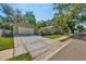 Home exterior featuring a detached garage and a spacious driveway, complemented by lush green lawn and mature trees at 1155 Withlacoochee St, Safety Harbor, FL 34695