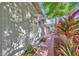 Home exterior with brick path, colorful plants, and trees provide a private walkway to the front entrance at 1155 Withlacoochee St, Safety Harbor, FL 34695