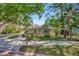 Charming home exterior featuring a green lawn, shade trees, and flowering plants, enhancing its curb appeal at 1155 Withlacoochee St, Safety Harbor, FL 34695