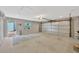 Open garage area with a concrete floor, overhead lighting, and a view of the exterior door and window at 1155 Withlacoochee St, Safety Harbor, FL 34695