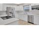 Kitchen area featuring stainless steel appliances, white quartz counters, new cabinets, and wood-look flooring at 1155 Withlacoochee St, Safety Harbor, FL 34695