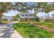 Charming two-story home with a large front yard, mature trees, and a brick walkway to the front door at 1211 S Druid Ln, Tampa, FL 33629
